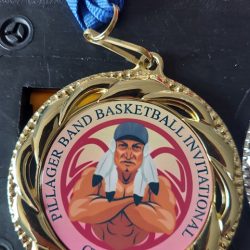 Gold medal with a blue ribbon labeled "Pillager Band Basketball Invitational Champion," featuring a flexing figure.