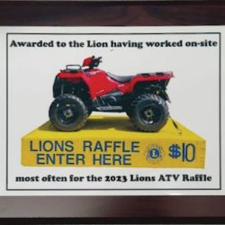 A plaque displaying a red ATV with text promoting a $10 Lions ATV raffle for 2023 and on-site work recognition.