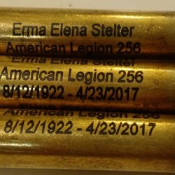 Three engraved bullet casings display the name Erma Elena Stelter, dates 8/12/1922 - 4/23/2017, and American Legion 256.