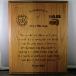 A wooden appreciation plaque honoring Brad Walhof for service to the Leech Lake Band of Ojibwe and KOJB Radio Station.