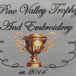 Logo for Pine Valley Trophy and Embroidery featuring a gold trophy and the text "est. 2014" on a gray background.